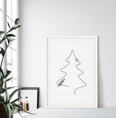 a black and white drawing of a christmas tree on a wall next to a potted plant