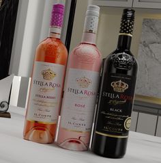 three bottles of wine sitting on top of a counter next to a mirror in a room