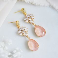 "These whimsical pink drop earrings are the perfect boho bridal earrings for the modern bride. The delicate faceted pink teardrops have a soft glow and are set inside of raw brass which have a warm patina finish enhancing their romantic appeal. The gold plated earring posts are created with sparkling oval cubic zirconia and secured to nature inspired ornate floral cz charms. Whether searching for unique bohemian wedding earrings for your bridesmaids or statement earrings for your next special occasion, all of my jewelry arrives suitably gift wrapped ready for gift giving. Measurements: The whimsical wedding earrings hang approx. 2\" long Metals: Gold plated brass cubic zirconia Gold plated brass posts Gold plated brass butterfly clutches 14k gold filled jump rings raw brass pink teardrop b Bohemian Dangle Crystal Earrings For Wedding, Feminine Crystal Drop Earrings For Wedding, Feminine Teardrop Wedding Earrings, Pink Dangle Earrings For Wedding, Pink Dangle Jewelry For Wedding, Bohemian Crystal Drop Earrings For Wedding, Pink Teardrop Jewelry For Wedding, Pink Teardrop Chandelier Earrings For Gift, Pink Drop Earrings For Wedding