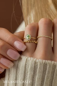 a woman's hand with two rings on her fingers and one ring in the middle