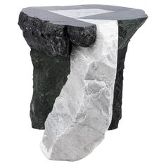 a black and white stone table with an irregular design on it's side, against a white background