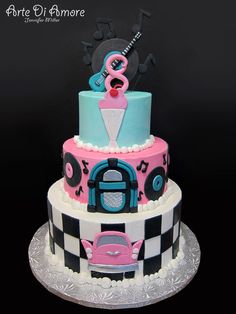 a three tiered cake decorated in pink, blue and black with an animal on top