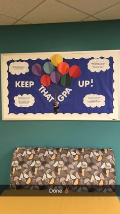 a bulletin board hanging on the wall above a bench in a room with blue walls