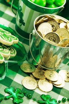 a table topped with lots of green and gold shamrocks next to potted plants