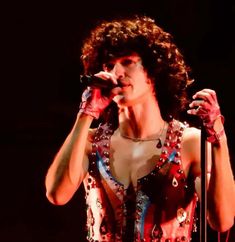 an image of a woman that is singing into a microphone and holding her hand up to her mouth