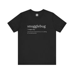 Embrace comfort and style with our Snugglebug T-Shirt. This classic black tee features a playful definition of 'snugglebug' in a stylish font, making it a perfect choice for pet lovers and cuddle enthusiasts alike. Crafted from soft, breathable fabric, it ensures all-day comfort while showcasing your love for those cozy moments.         Why You'll Love It: 👕 Ultimate Comfort: Made with 100% Airlume combed and ring-spun cotton, this tee offers a lightweight (4.2 oz/yd² or 142 g/m²) and breathabl Funny Black T-shirt With Name Print, Cozy Moments, Stylish Fonts, Meet Friends, Just Relax, Pet Lovers, Leisure Wear, Fashion Lover, Semi Formal