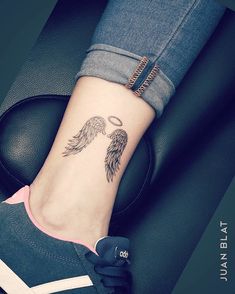 a woman's foot with an angel tattoo on it