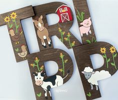 the letters are made out of wood and have farm animals on them, such as cows