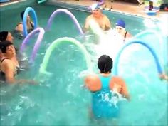 people are playing in the pool with water hoses