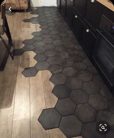 a kitchen floor with hexagonal tiles on it and an oven in the background