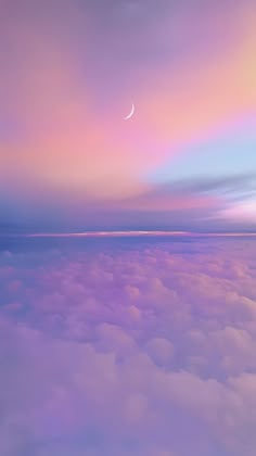 an airplane wing flying above the clouds at dusk with a half moon in the sky