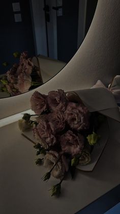 a bouquet of flowers sitting on top of a counter in front of a bathroom mirror