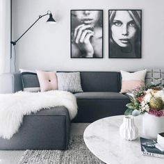 a living room with two pictures on the wall and a coffee table in front of it