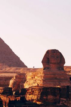 the sphinx and pyramids are in front of each other at giza, egypt