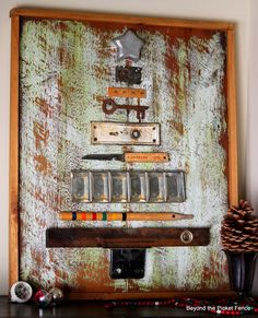 an old wooden frame with various items on it and a pine cone next to it