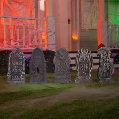 tombstones in front of a house decorated for halloween