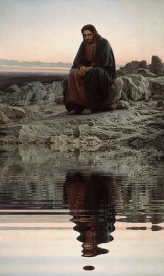 a man sitting on top of a rock next to water