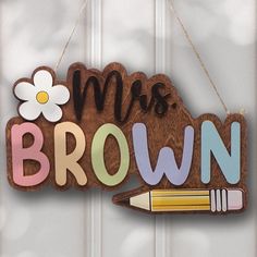 a wooden sign that says, miss brown with a pencil and flower on the front