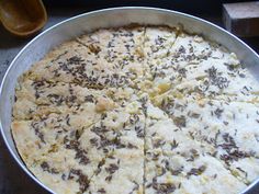 a pan filled with food sitting on top of a table next to a wooden spoon