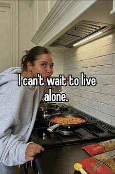 a woman standing in front of a stove top oven