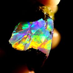 a person holding an opal in their hand