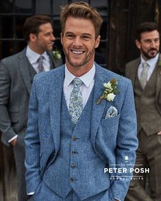 a man in a blue suit and tie standing next to other men