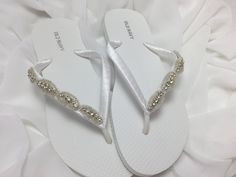 White bridal flip flops are wrapped with white satin ribbon and the straps are decorated with a rhinestones trim with beads Ribbon color is white if you are needing other colors of ribbon or decoration please contact me and will be happy to accommodate you! All flip flops are handmade to order and the production time is 5-7 business days and then please allow additional time for shipping.  On a larger order please contact me. Amazing for beach, weddings, flower girl or a fancy event, you choose! White Sandals With Rhinestones And Adjustable Fit, Elegant Silver Beach Flip Flops, White Open Toe Flip Flops For Wedding, Elegant Rhinestone Wedding Flip Flops, Elegant Rhinestone Flip Flops For Wedding, Elegant Wedding Flip Flops With Rhinestones, White Adjustable Flip Flops For Wedding, Adjustable White Flip Flops For Wedding, Flip Flops Wedding