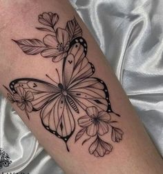 a black and white butterfly tattoo on the arm