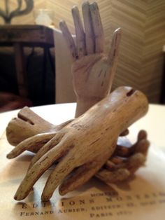 a hand made out of drift wood sitting on top of a table