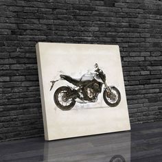 a black and white photo of a motorcycle on a wall next to a brick wall