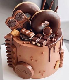 there is a chocolate cake decorated with donuts and other things on top of it