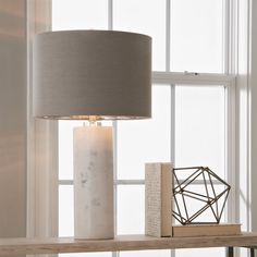 a table lamp sitting on top of a wooden shelf