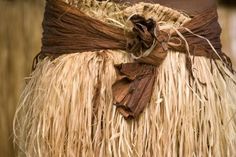 a close up of a person wearing a straw skirt