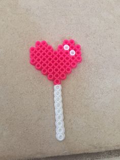 a pink and white heart shaped lollipop on top of a counter next to a wall