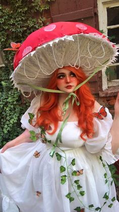 a woman with red hair wearing a large hat