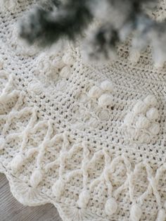 a white crocheted doily with pine needles