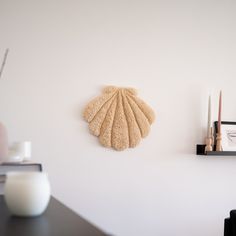 a wall mounted scallop on the side of a white wall next to a black shelf