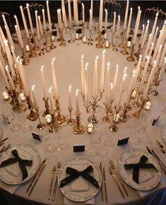 the table is set with candles and place settings for an elegant dinner or reception party