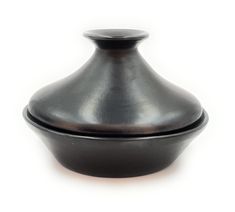 a black vase sitting on top of a white table