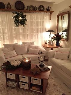 a living room filled with white furniture and christmas decorations on top of a coffee table