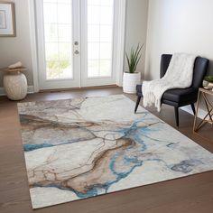 a living room area with a rug, chair and potted plant