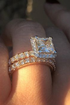 a close up of a person's hand holding a diamond ring