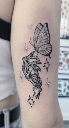 a woman's arm with a tattoo on it that has a butterfly flying over her head