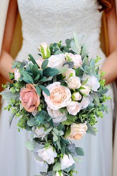 a bridal holding a bouquet of flowers and greenery