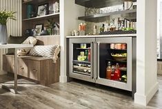 an open refrigerator with drinks in it next to a dining room table and shelves on the wall