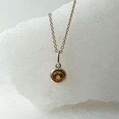 Materials: 14k Gold Gemstone: Genuine Citrine Total Citrine Carat Weight: 0.16 ct. Pendant Diameter: 11mm x 5.4mm (including bale) Citrine Size: 3.5mm x 3.5mm Necklace: Adjustable 16 and 18 inches with a lobster clasp. Chain Weight: 0.6mm 1.35 grams Description: Option for pendant only, necklace available as an add on. The necklace is 16 and 18 inches adjustable, with a lobster clasp at the end. Please check measurements prior to purchasing, as this is a dainty pendant. A beautiful round citrine 14k Gold Gemstones With Bezel Setting, Round Gemstones With Bezel Setting In 14k Gold, 14k Gold Round Gemstones With Bezel Setting, Classic Yellow Gold Birthstone Gemstones, Yellow Gold Birthstone Necklace With Round Stone, Gold Gemstones Birthstone, Yellow Gold Briolette Birthstone Gemstones, Gold Gemstones With Bezel Setting In Fine Jewelry, Yellow Gold Gemstones With Bezel Setting