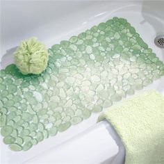 a white bath tub sitting next to a green towel