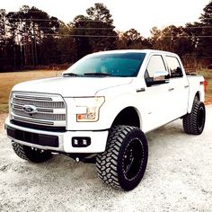 a white truck parked on top of a gravel road