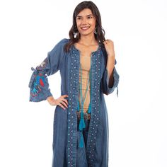 Denim Duster. This Bold Maxi Denim Duster Features Colorful Dream Catcher Embroidery On The Sleeves With Denim Band Ties At The Elbow. Geometric Embroidered Bands Run Down The Placket And Around The Neck, And Have A Tassel Tie Front Closure. Import. Hand Wash Separately In Cold Water Or Dry Clean Recommended.. Bohemian Long Sleeve Outerwear In Medium Wash, Bohemian Long Sleeve Medium Wash Outerwear, Bohemian Medium Wash Long Sleeve Outerwear, Bohemian Denim Top For Fall, Dark Wash Bohemian Outerwear For Fall, Bohemian Dark Wash Outerwear For Fall, Bohemian Denim Top For Spring, Bohemian Summer Denim Jacket In Medium Wash, Bohemian Denim Blue Summer Outerwear