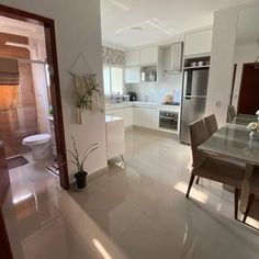 an open kitchen and dining room with white tile flooring